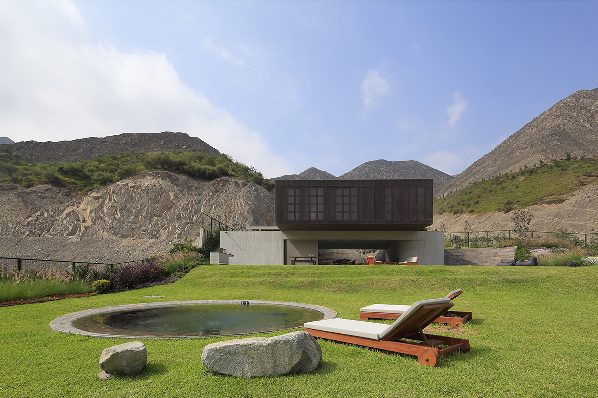 Large semi-buried social space creates a rustic and organic feeling under wooden volume built in Peru