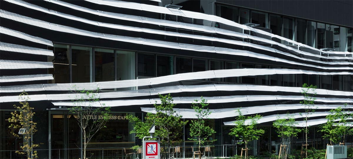 Kengo Kuma wraps alumni building in Tokyo with irregular metal surface creating organic skin