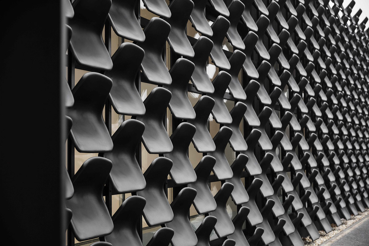 Architects use more than 900 black plastic seats for a gallery to create easily remembered building