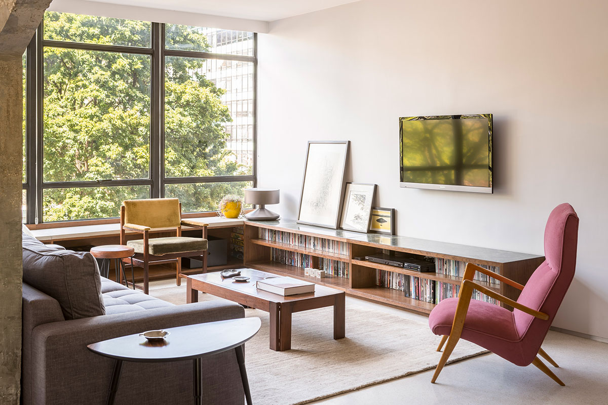 A historic Brazilian apartment has been redesigned with wooden bookcase as main divider