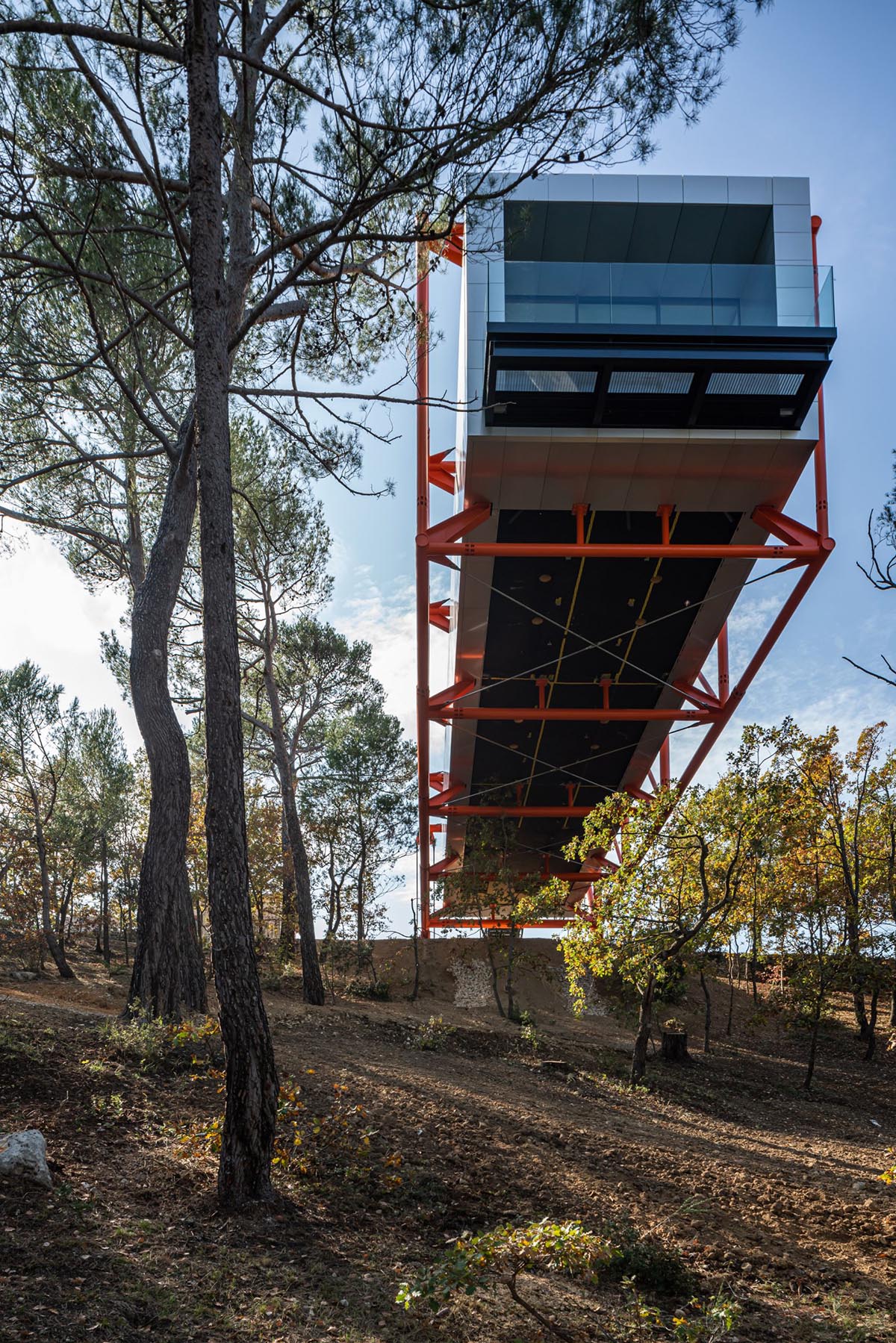 Richard Rogers new gallery supported by orange steel beams cantilevers out  27 meters over hillside