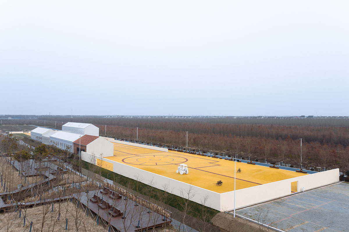 Wutopia Lab converts abandoned barnyard into a golden yellow field resembling a frozen harvest time