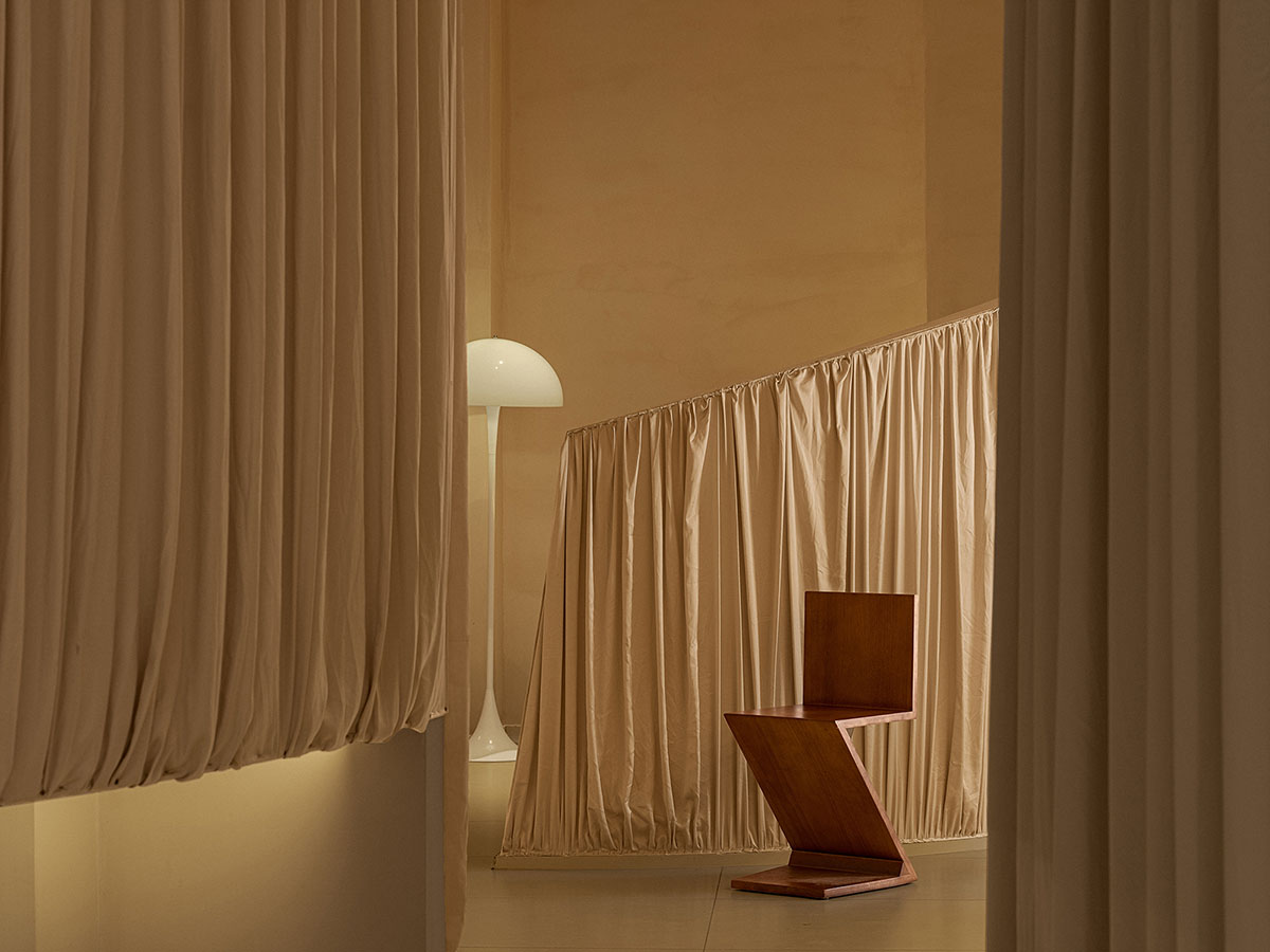 Tea house interiors wrapped by earth-toned fabric curtains act like 
