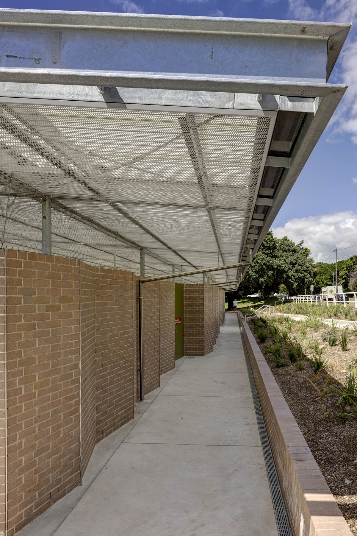 Sports pavilion is made of zigzagging brick walls referencing serrated leaves of endangered banksia