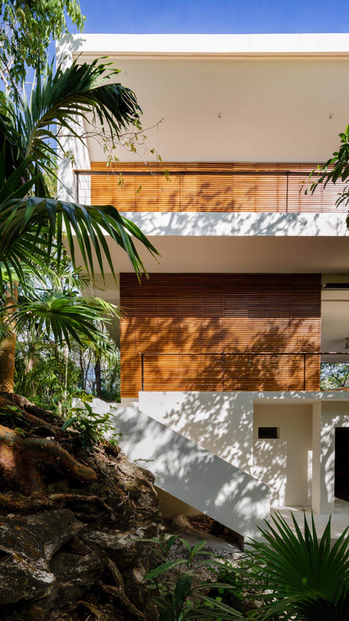 Sordo Madaleno Arquitectos' L-shaped residence disappears in a lush vegetation of Mexican island