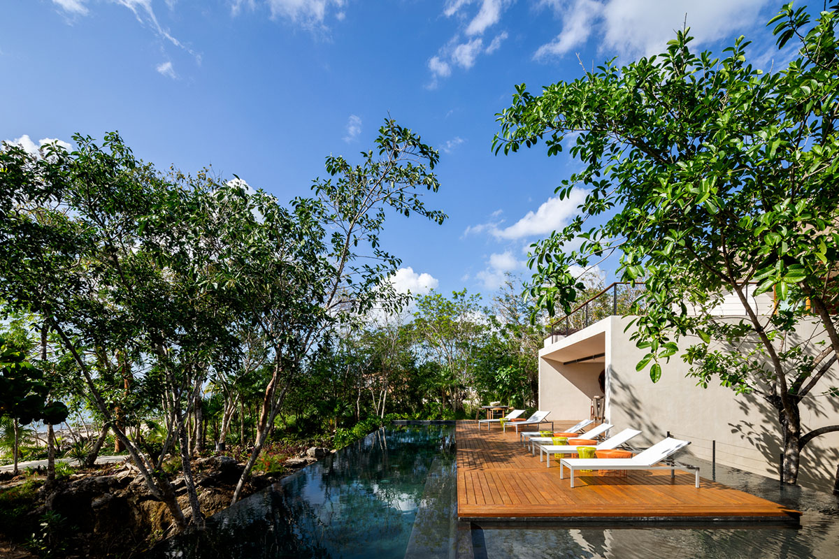 Sordo Madaleno Arquitectos' L-shaped residence disappears in a lush vegetation of Mexican island