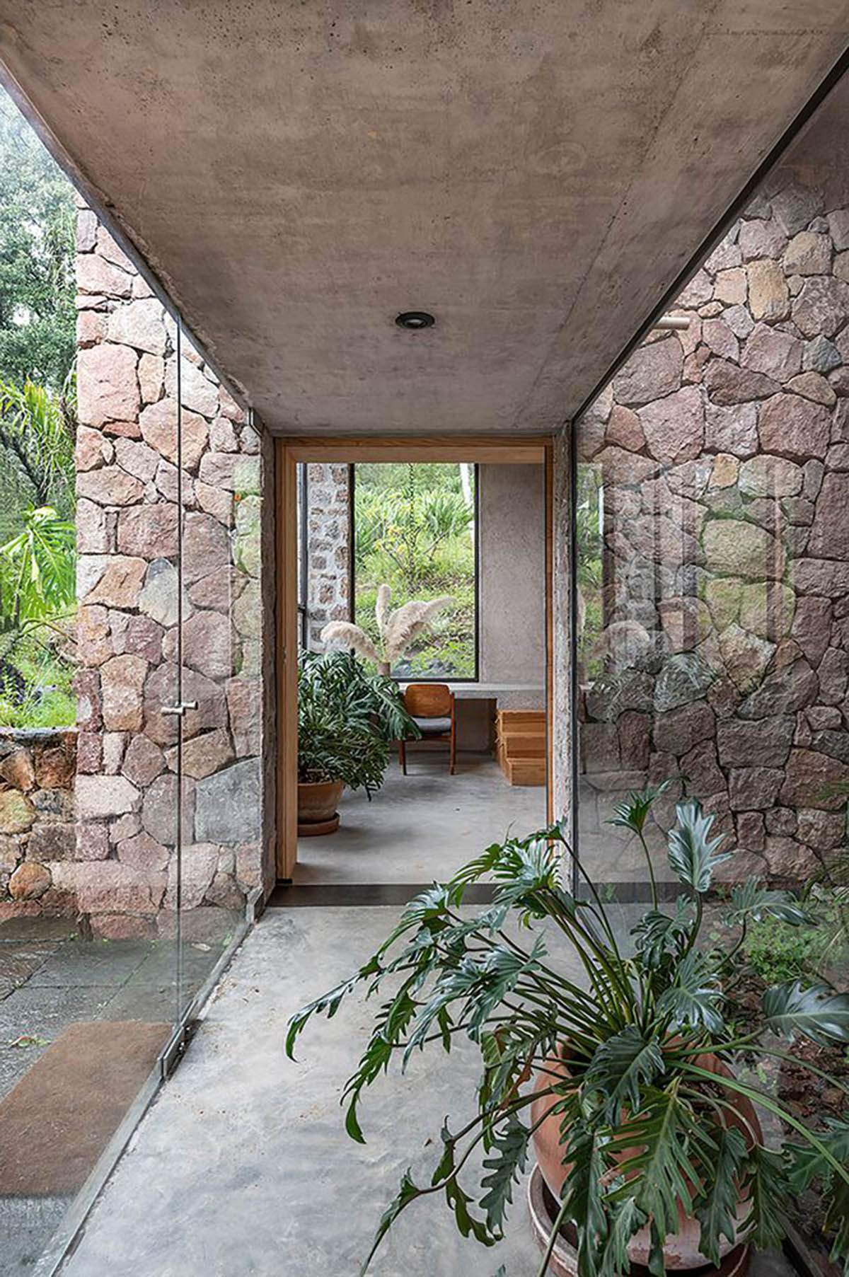 Luis Carbonell extends existing stone house with pastel-toned textured volume in a Mexican valley 