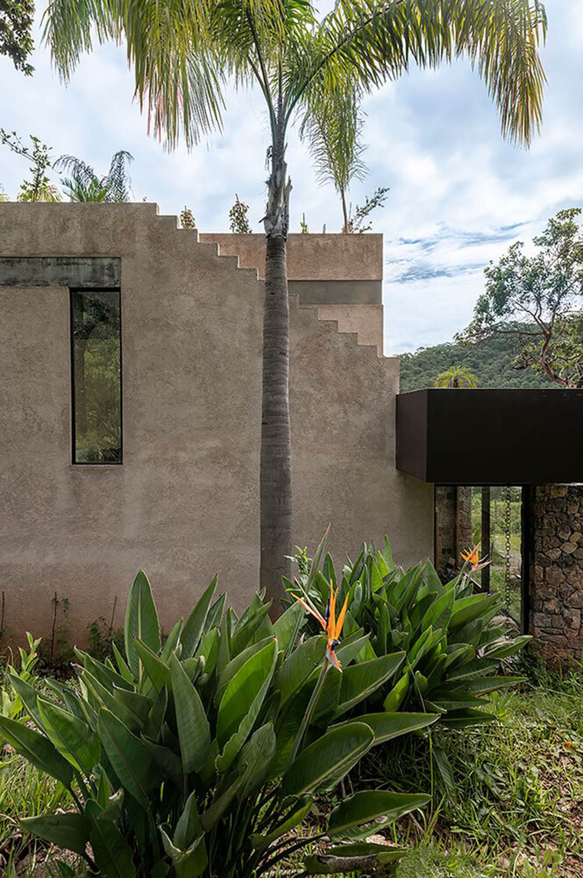 Luis Carbonell extends existing stone house with pastel-toned textured volume in a Mexican valley 