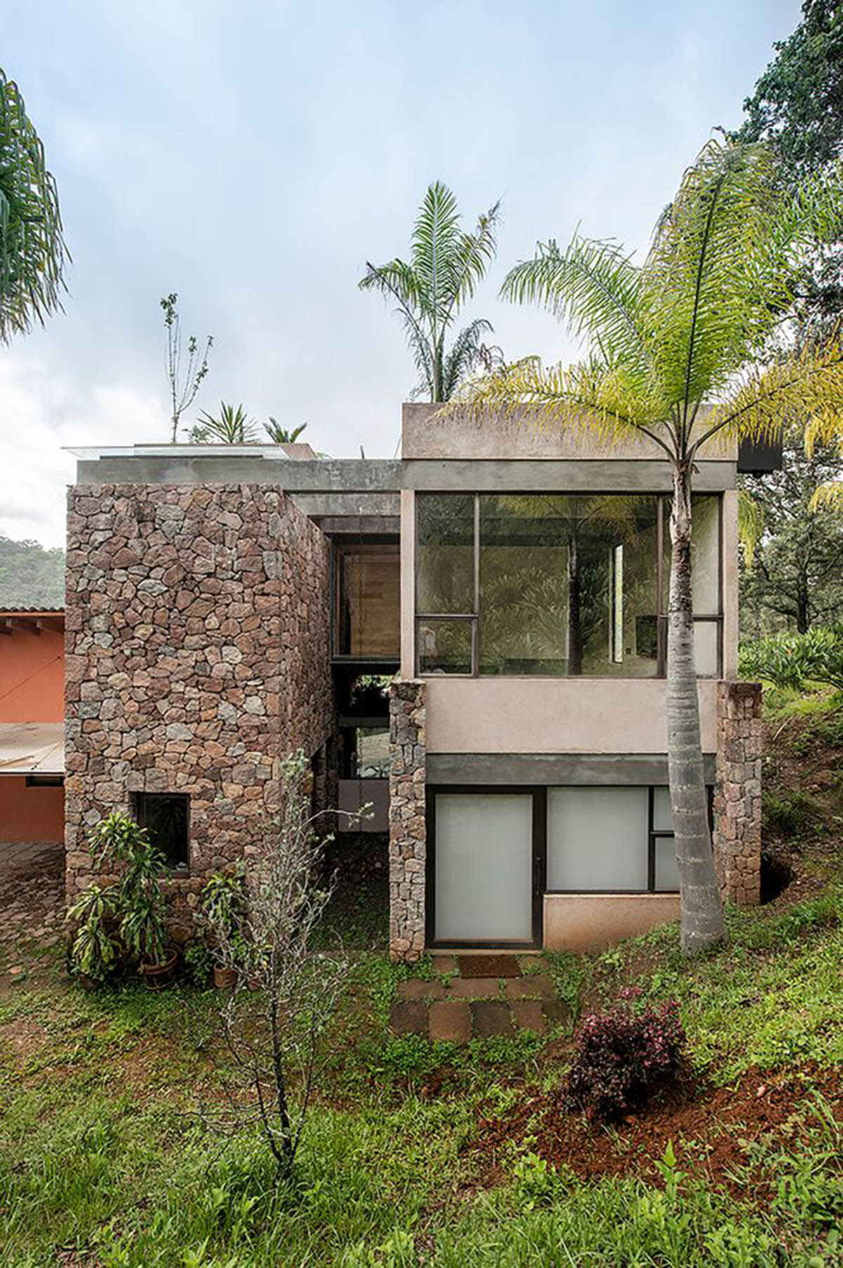 Luis Carbonell extends existing stone house with pastel-toned textured volume in a Mexican valley 