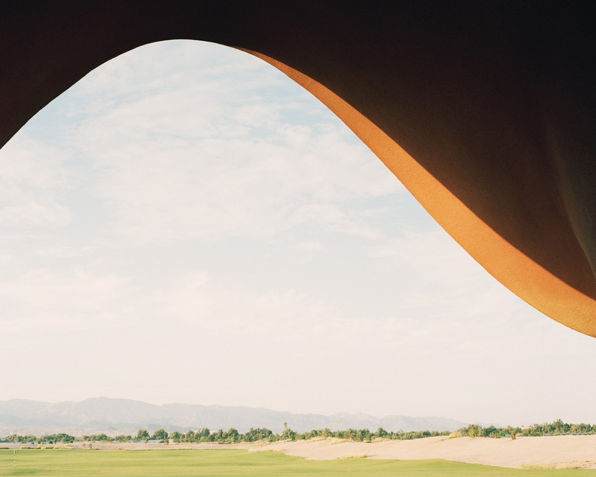 Smooth curves of a golf clubhouse by Oppenheim Architecture are derived from the natural desertscape