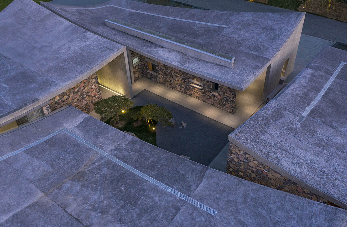 Concrete hyperboloid roofs cover masonry stone art center with a central courtyard in Shandong