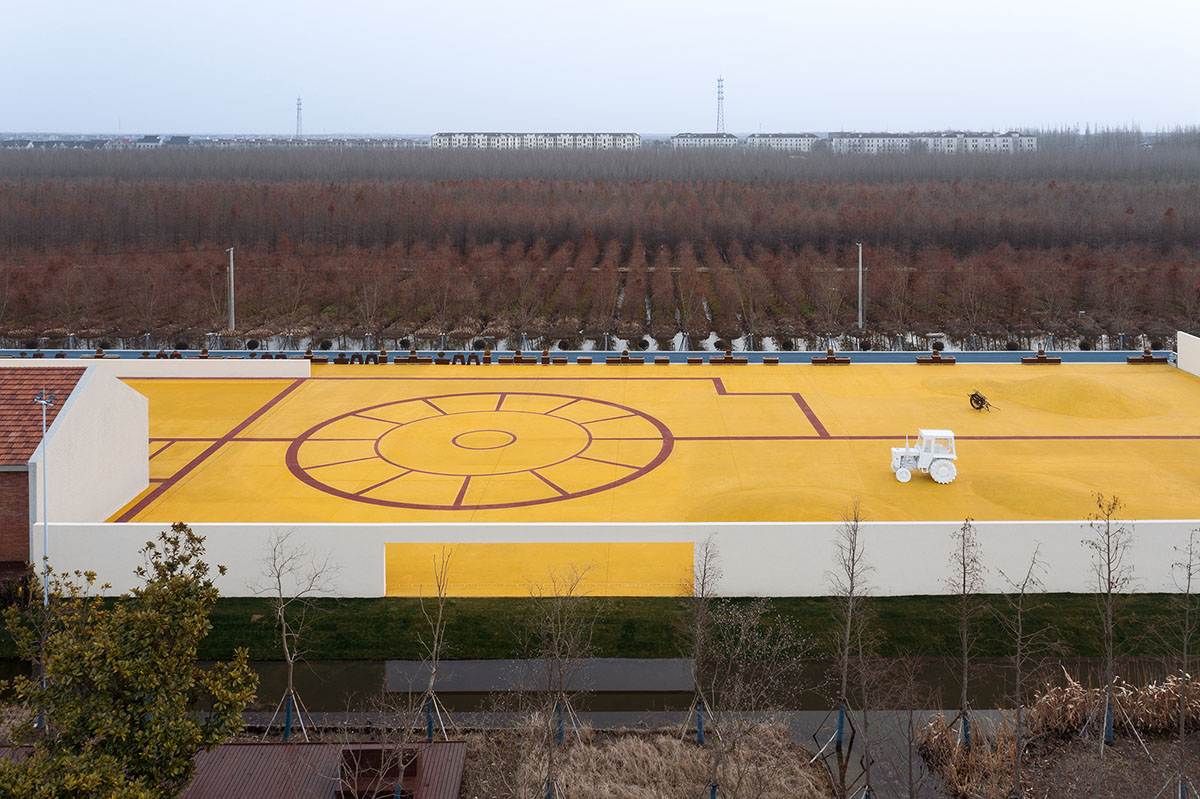 Wutopia Lab converts abandoned barnyard into a golden yellow field resembling a frozen harvest time