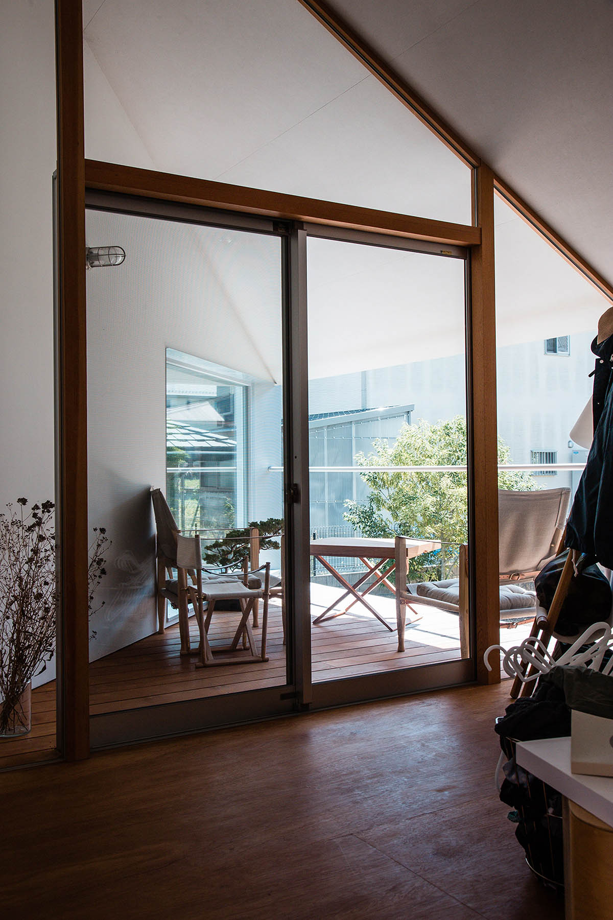Huge corrugated polycarbonate wall lightens a cornered sunroom in house by Tato Architects