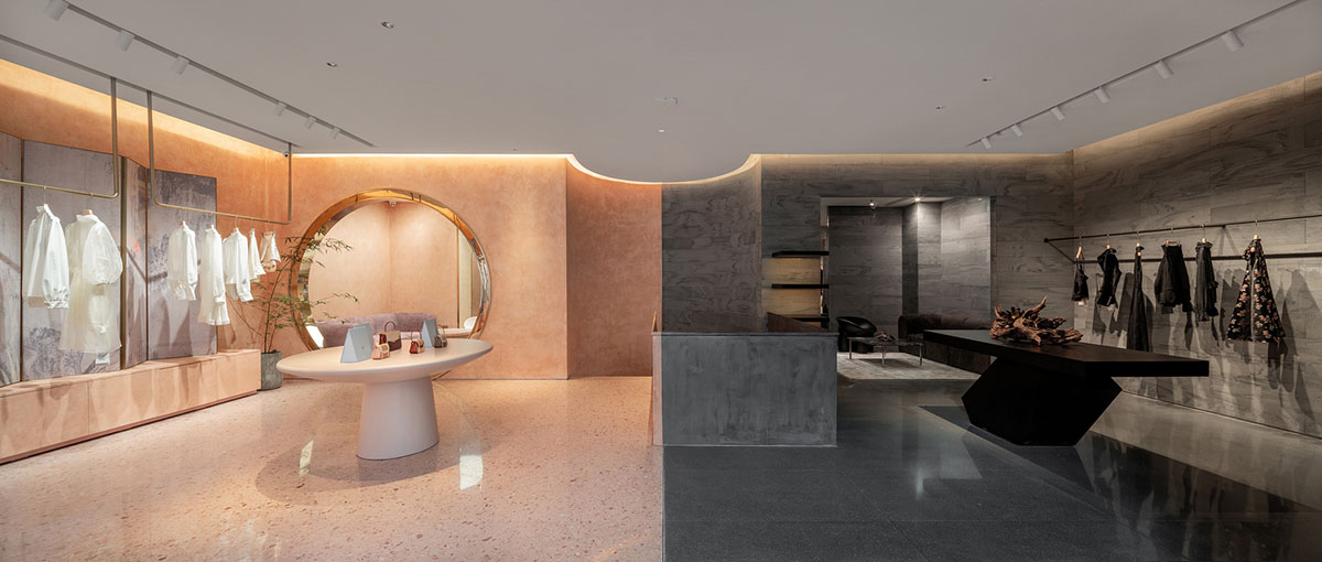 Pink elements and dark colors create sharp contrast in the interiors of restaurant and showroom