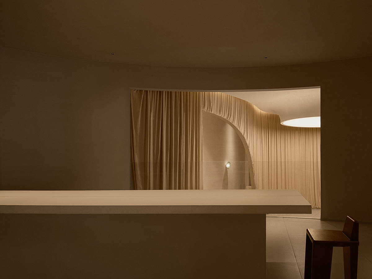 Tea house interiors wrapped by earth-toned fabric curtains act like 