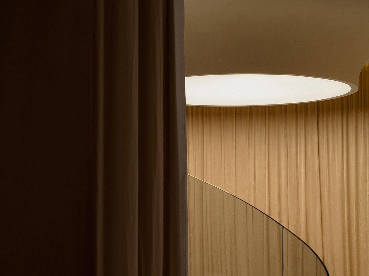 Tea house interiors wrapped by earth-toned fabric curtains act like 
