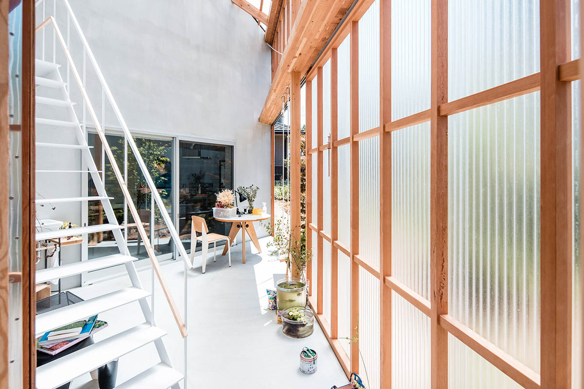 Huge corrugated polycarbonate wall lightens a cornered sunroom in house by Tato Architects