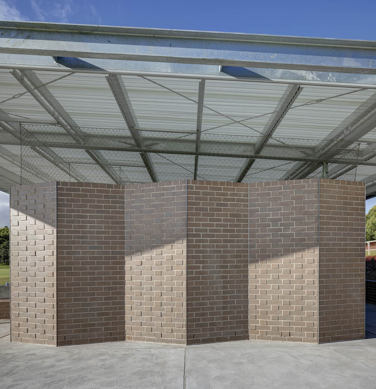 Sports pavilion is made of zigzagging brick walls referencing serrated leaves of endangered banksia