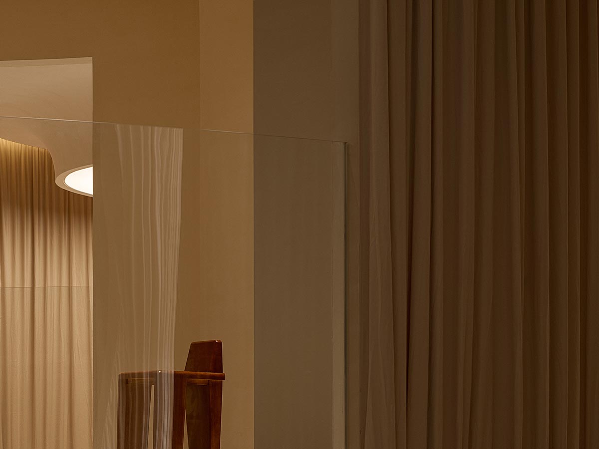 Tea house interiors wrapped by earth-toned fabric curtains act like 