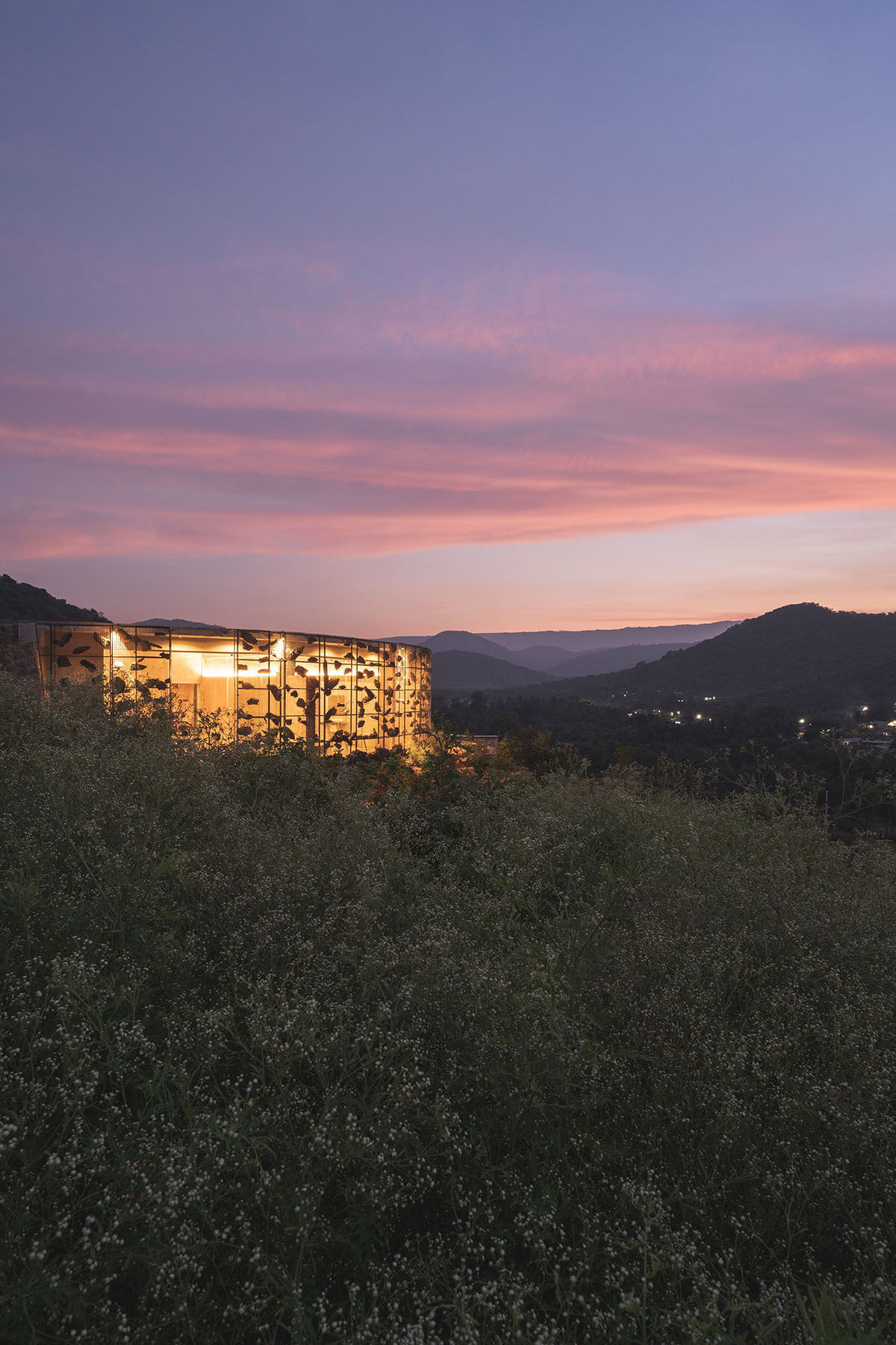 Farm house by Earthscape Studio is wrapped by gabion wall to filter light and airflow in India 