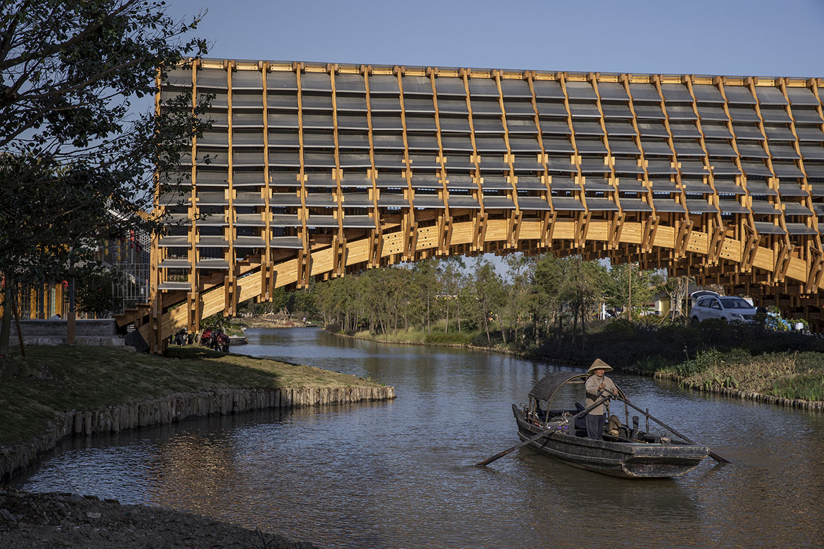 Arched timber bridge by LUO studio allows boats to pass under bridge smoothly in Gulou waterfront