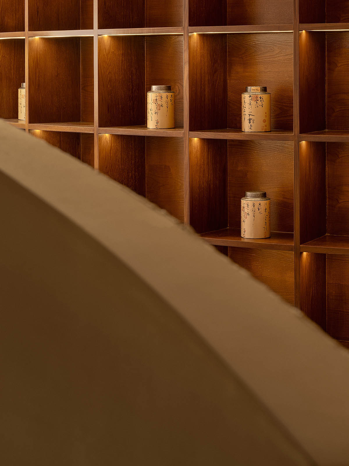 Tea house interiors wrapped by earth-toned fabric curtains act like 