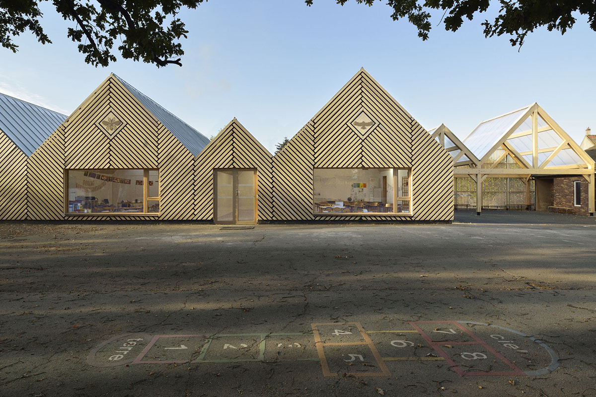 This human-scale school in French town wrapped by different geometry of wood claddings