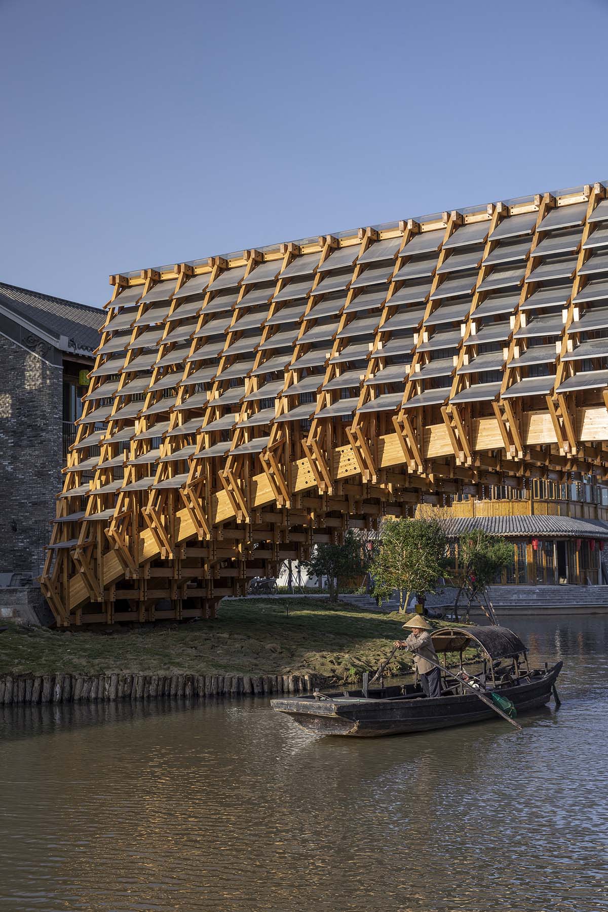 Arched timber bridge by LUO studio allows boats to pass under bridge smoothly in Gulou waterfront