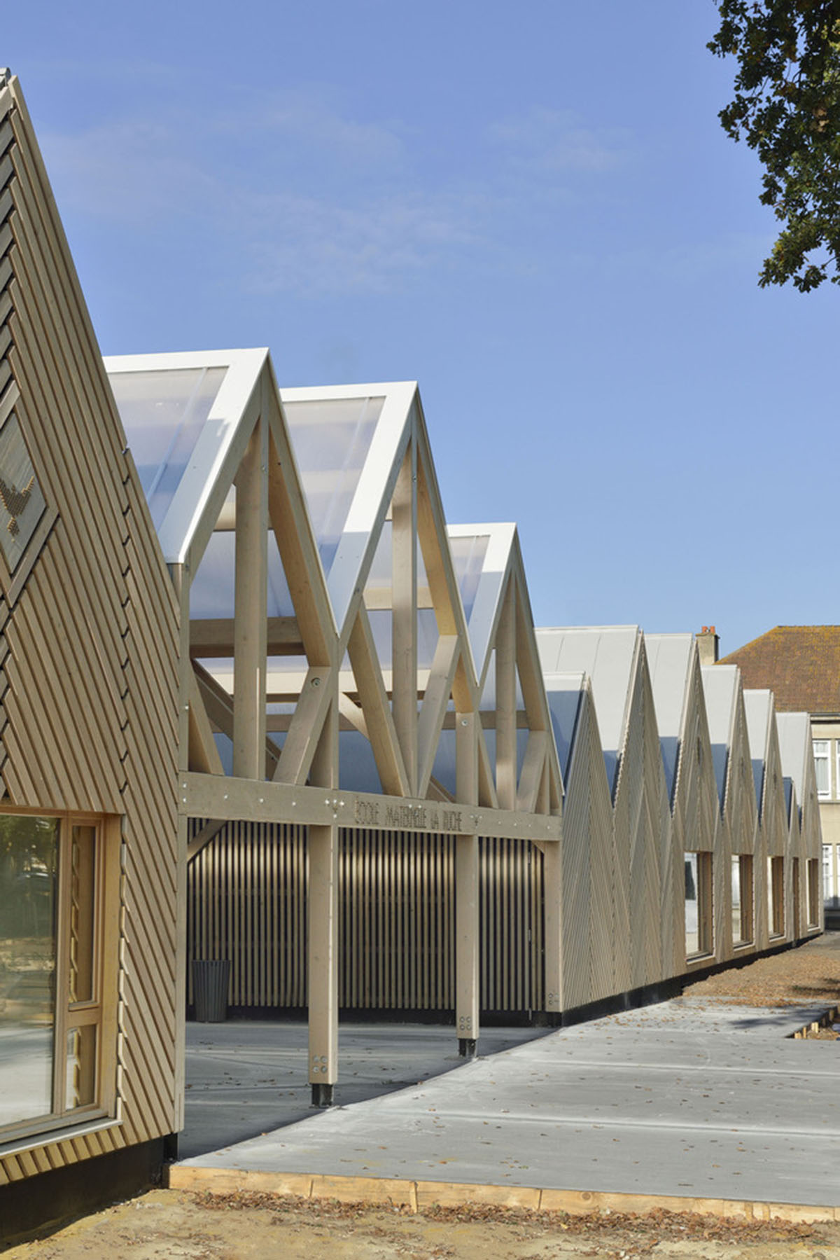 This human-scale school in French town wrapped by different geometry of wood claddings