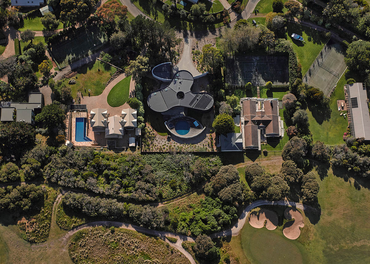 Wood Marsh built curvaceous home clad in dark timber contrasting its natural landscape in Portsea