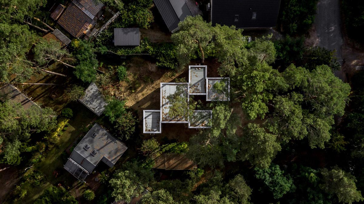 Zeller & Moye built private residence composed of interlocked timber cabins among pine trees