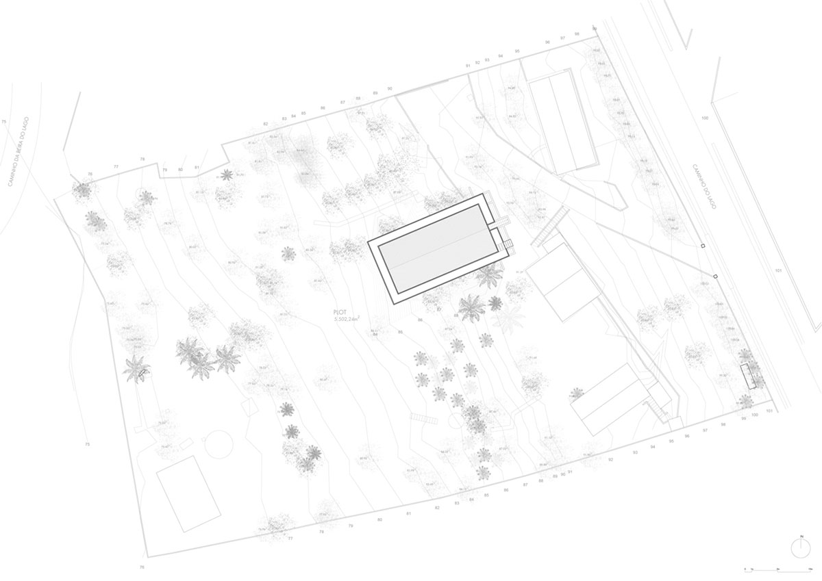 Two bold concrete platforms define this transparent library house by Atelier Branco Arquitetura