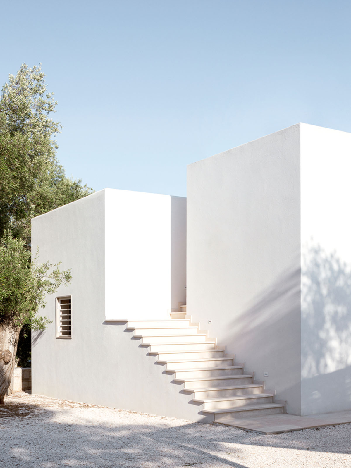 Noname Studio designs townhouse with all-white abstract sculpted volumes among olive trees