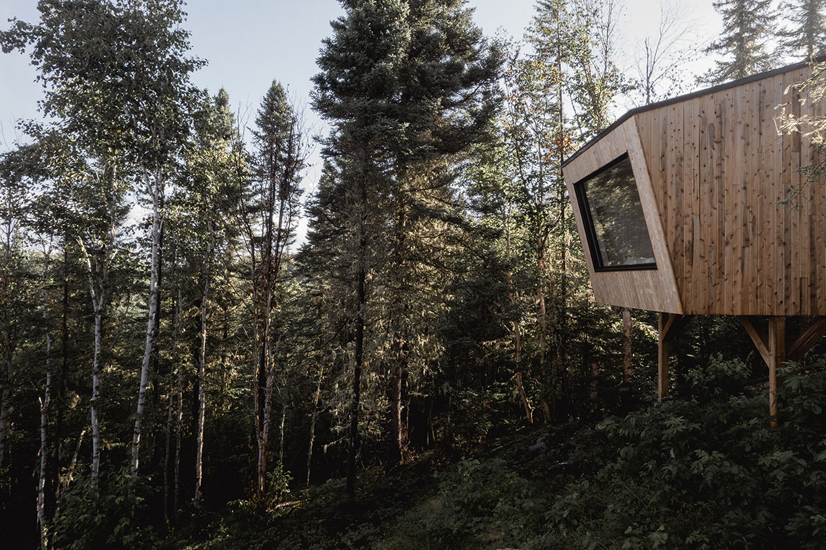 Canadian winter home designed by Atelier L'Abri looks like it is covered in  snow in the forest