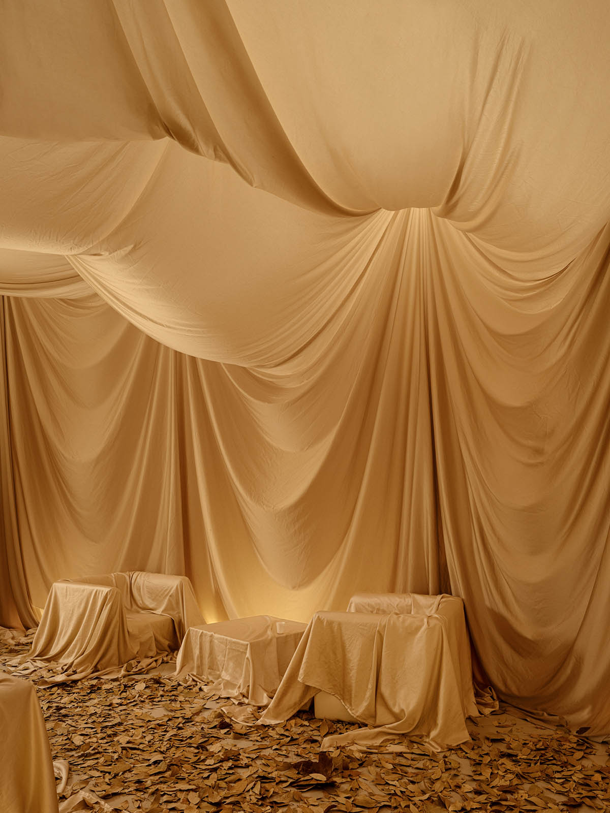 Tea house interiors wrapped by earth-toned fabric curtains act like 