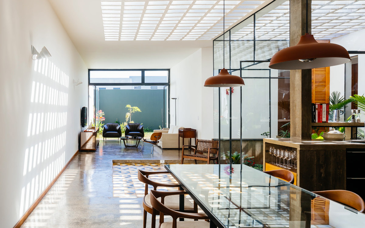 V&atilde;o designed recessed volumes and leaning red wall to offer flexible spaces for this Brazilian house