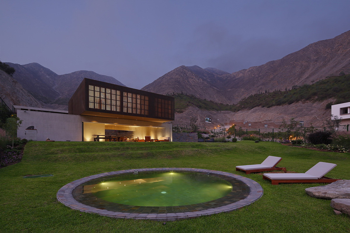 Large semi-buried social space creates a rustic and organic feeling under wooden volume built in Peru