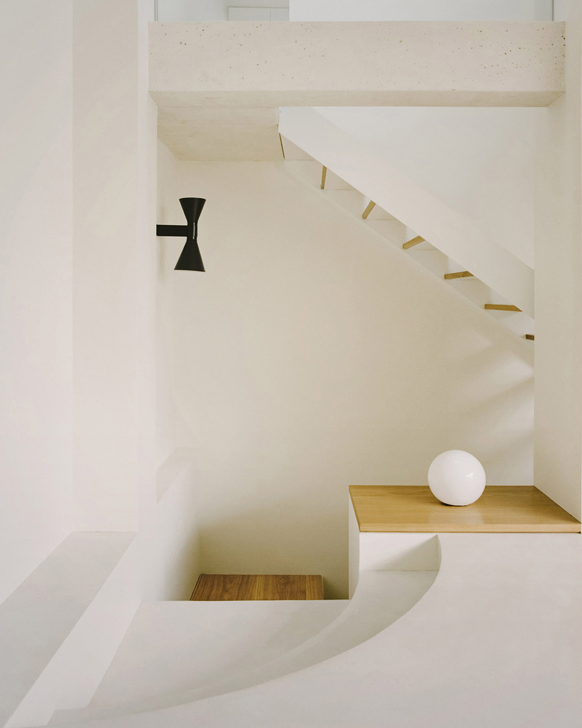 White concrete curved bridge gently complements interiors of The Island House in Paris