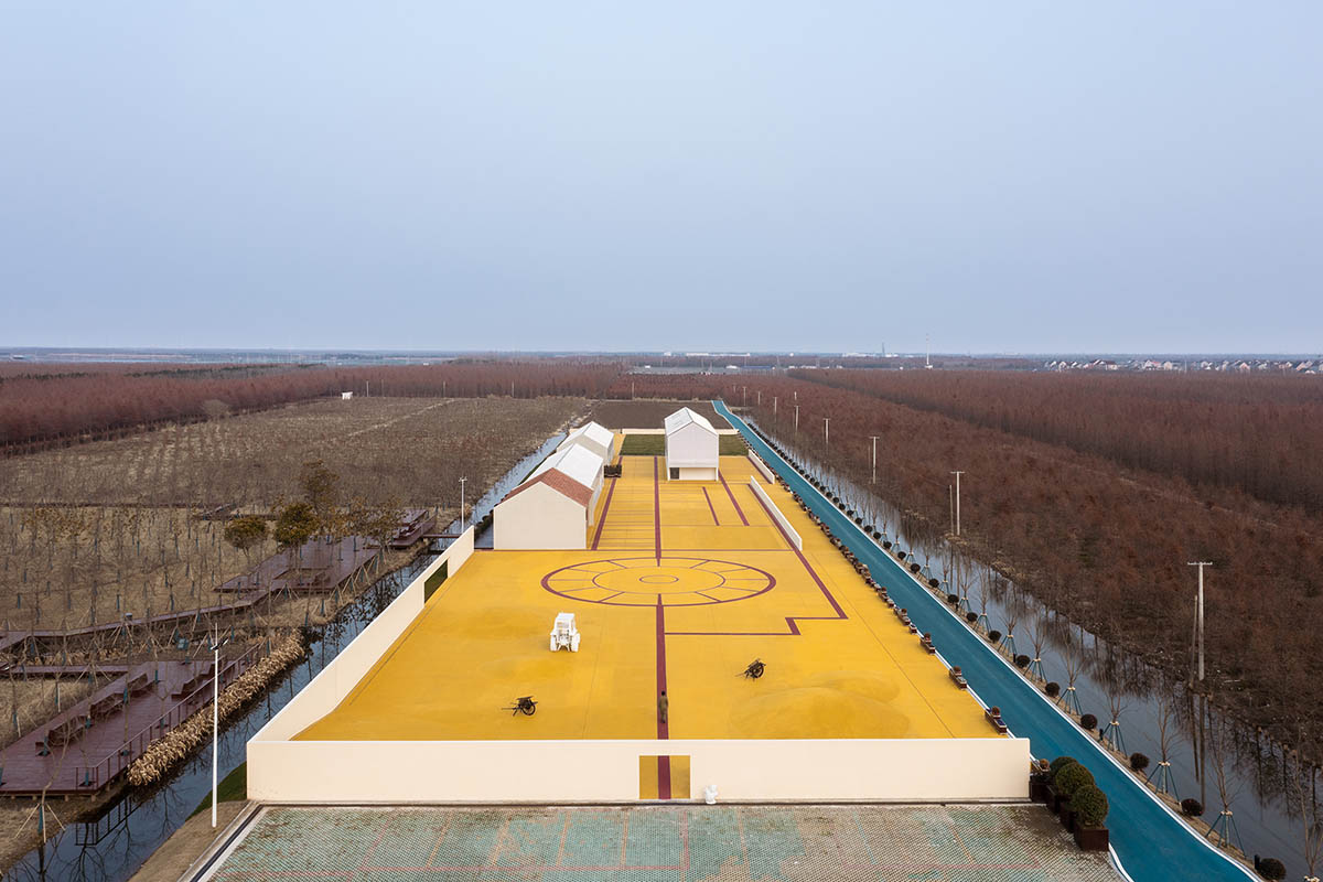 Wutopia Lab converts abandoned barnyard into a golden yellow field resembling a frozen harvest time