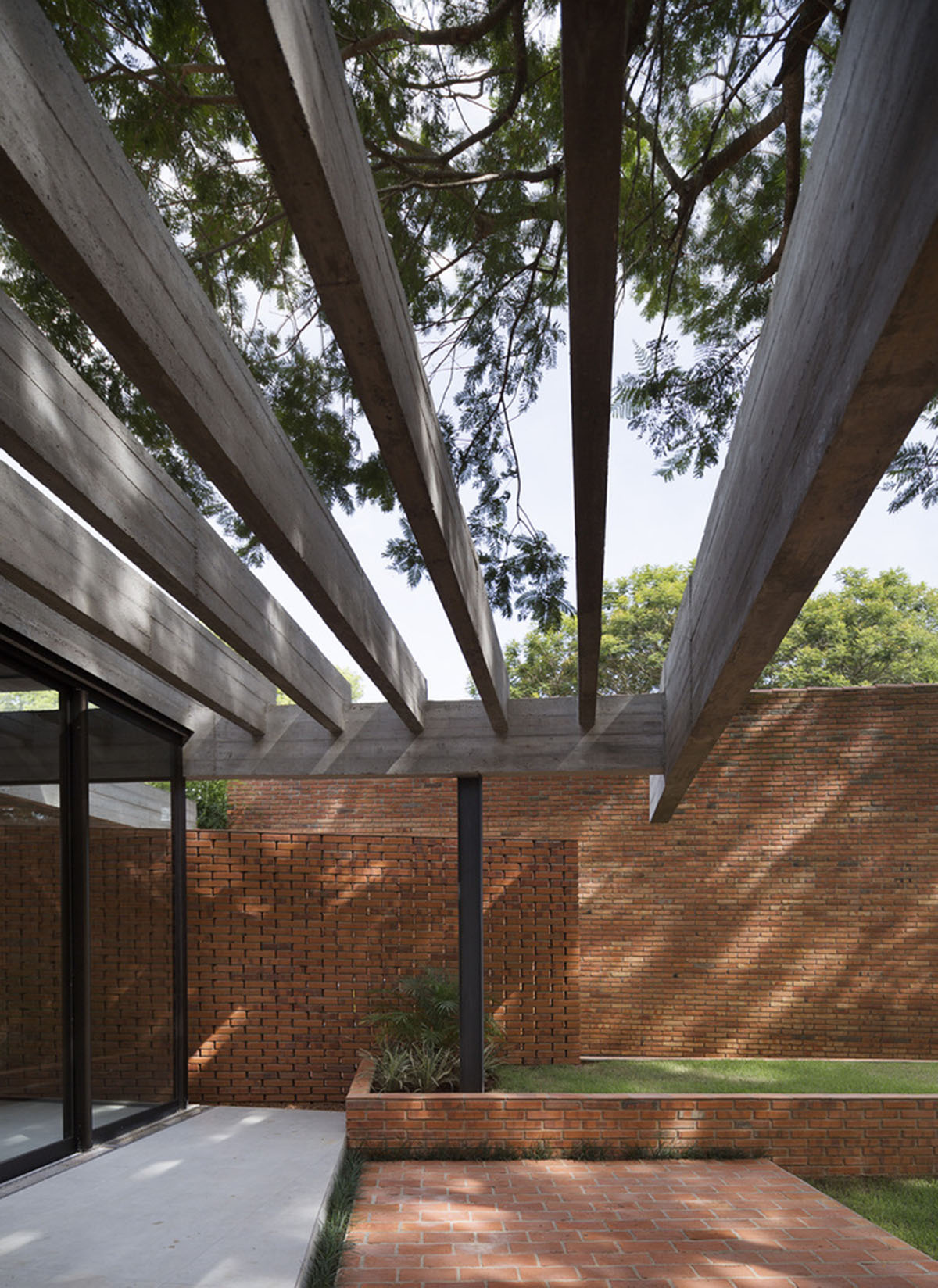 Concrete roof slabs and surfaces freely fly over this brick house in Paraguay by Culata Jovái Group