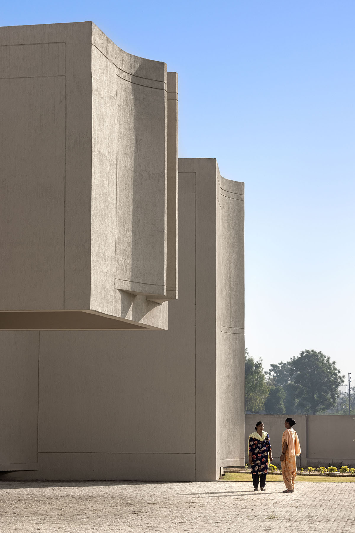Kamat & Rozario Architecture built school with fortress-like blank walls and colored bridges