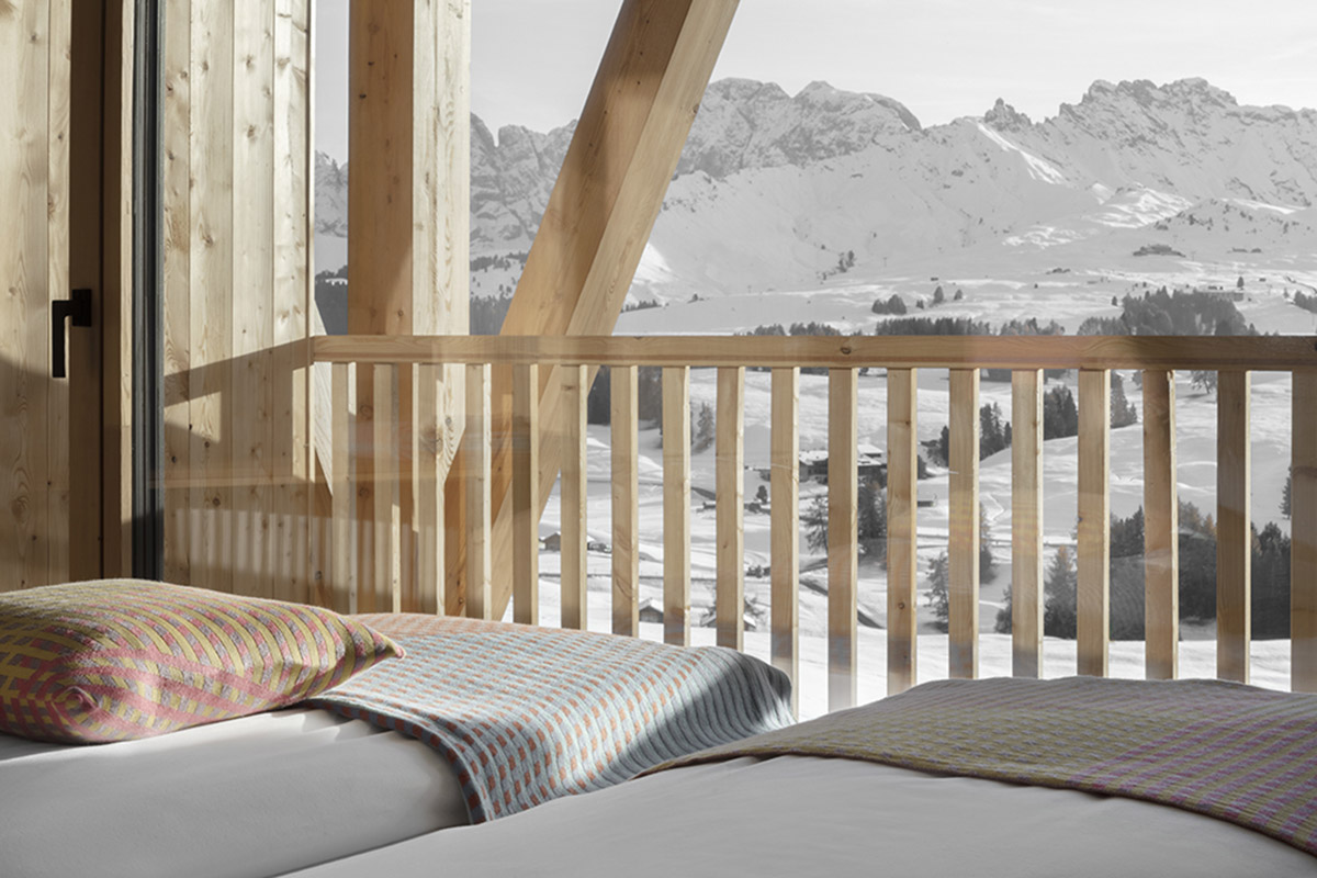 Icaro Hotel featuring wooden colonnade frames embraces alpine heritage landscape in Italy 