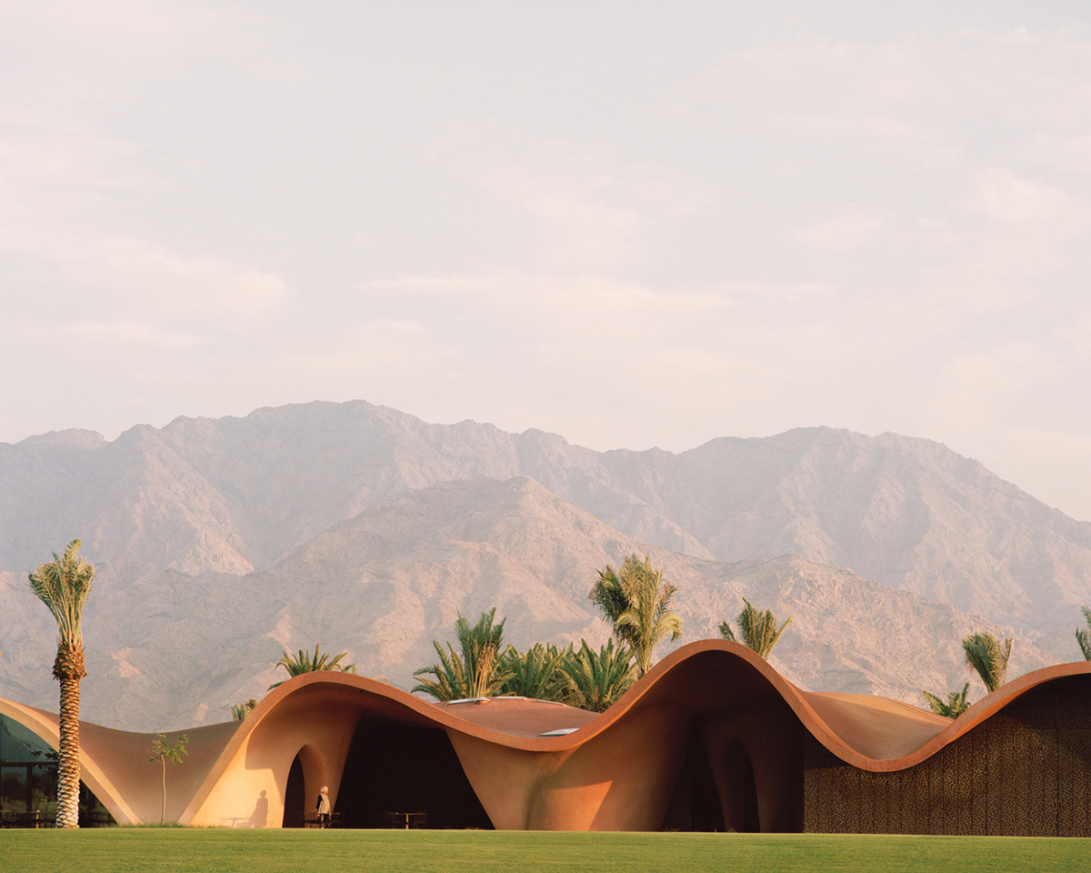 Smooth curves of a golf clubhouse by Oppenheim Architecture are derived from the natural desertscape