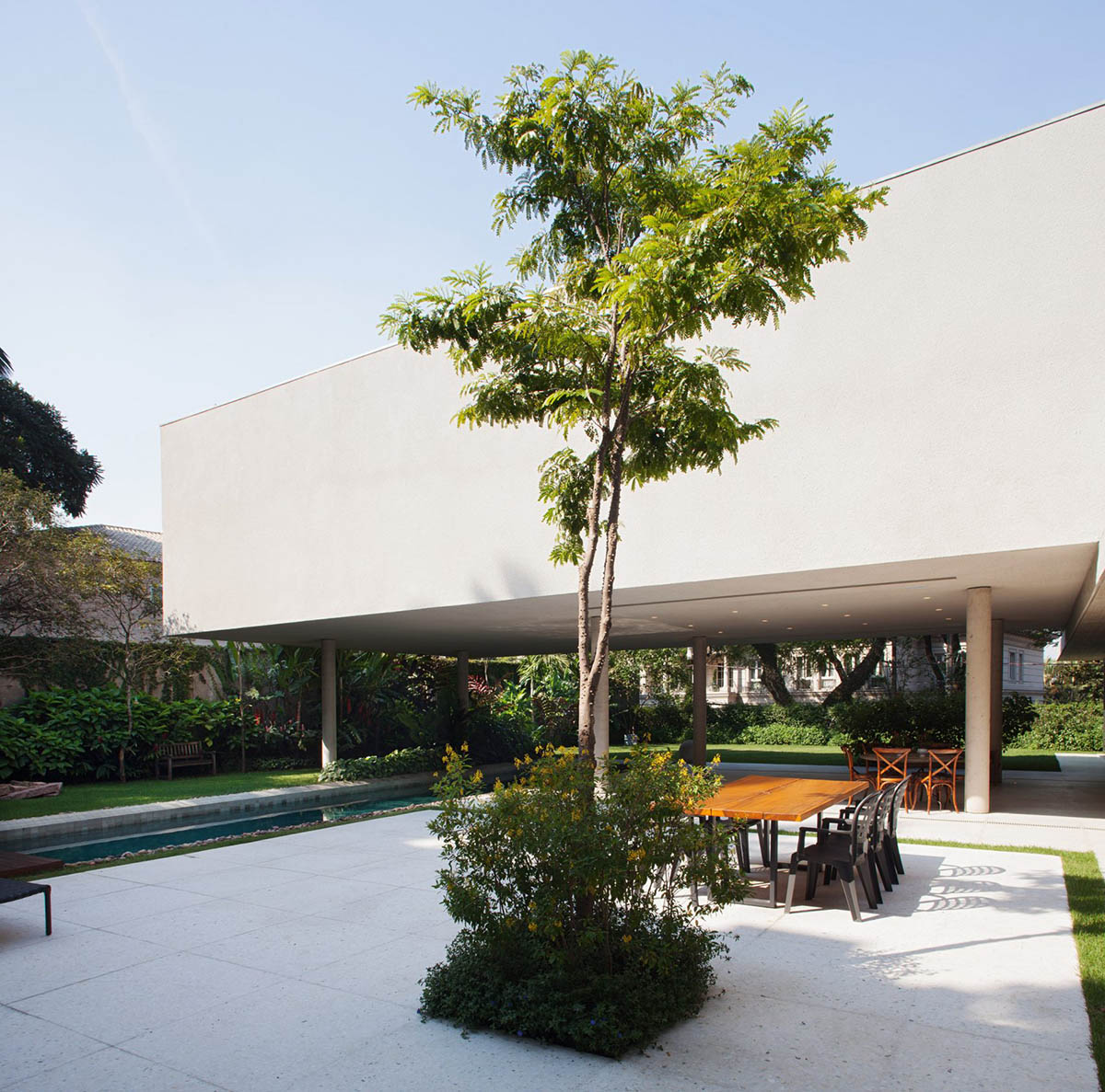 Perkins+Will's Cidade Jardim House features a large garden space under thin columns