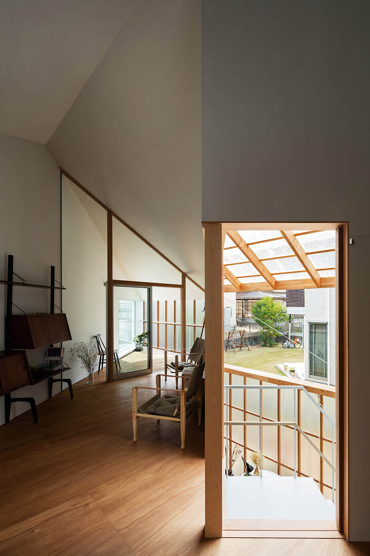 Huge corrugated polycarbonate wall lightens a cornered sunroom in house by Tato Architects