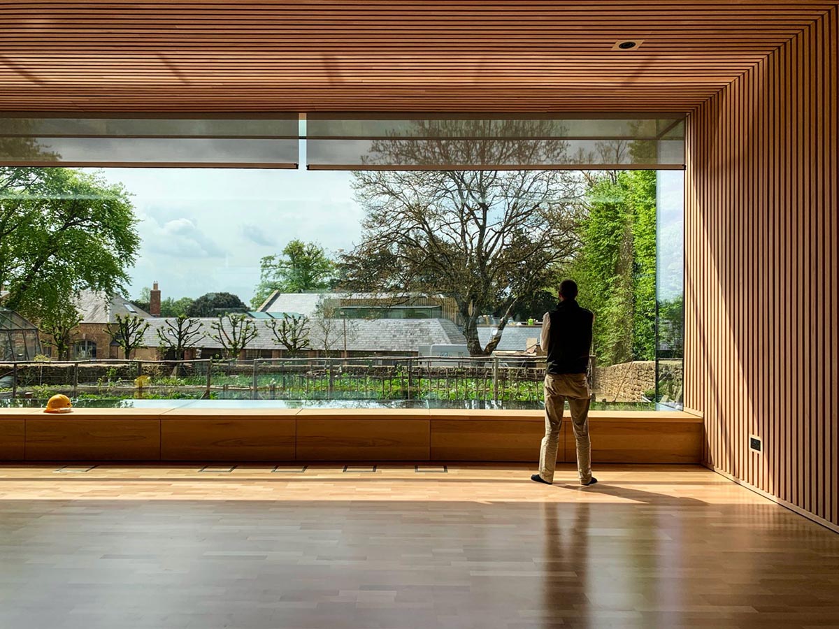 Invisible Studio creates large window for a gymnasium overlooking to a productive garden in Somerset