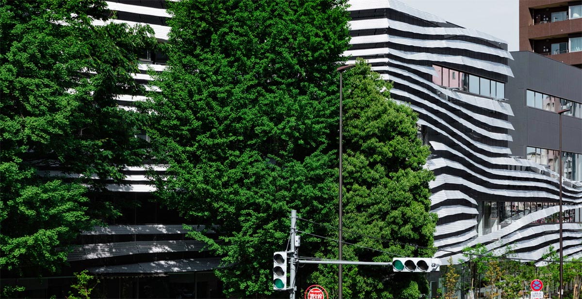 Kengo Kuma wraps alumni building in Tokyo with irregular metal surface creating organic skin
