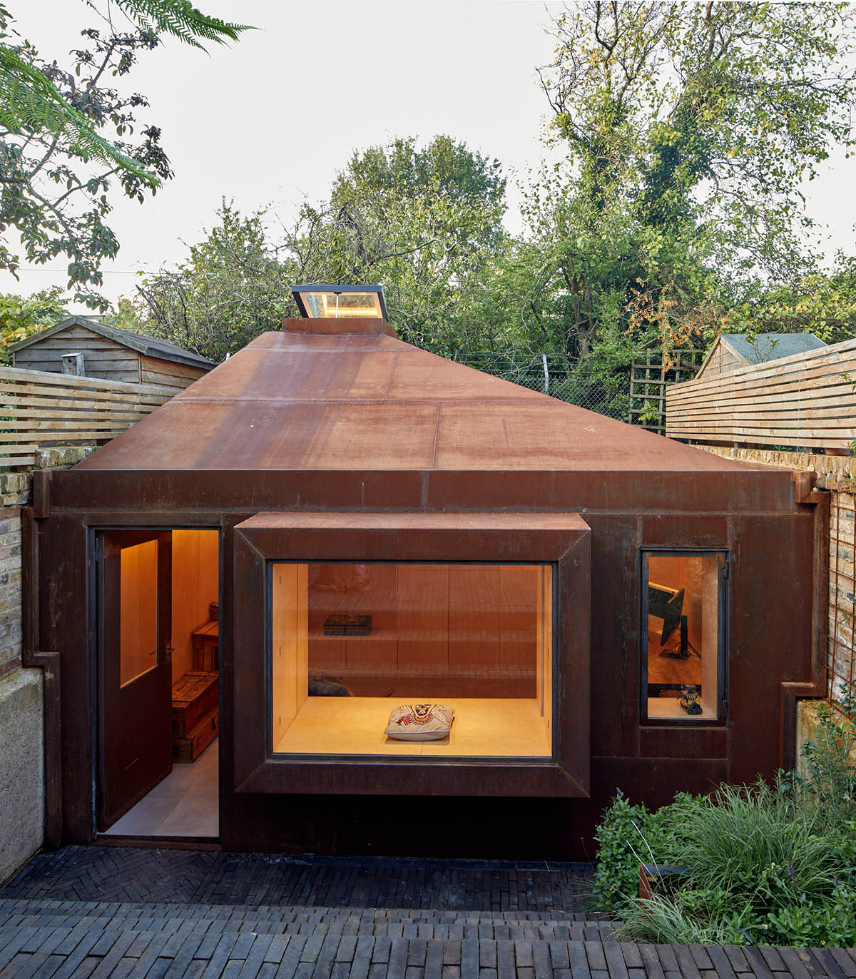 RISE Design Studio built sunken garden studio with rusted steel to provide a hidden place to escape