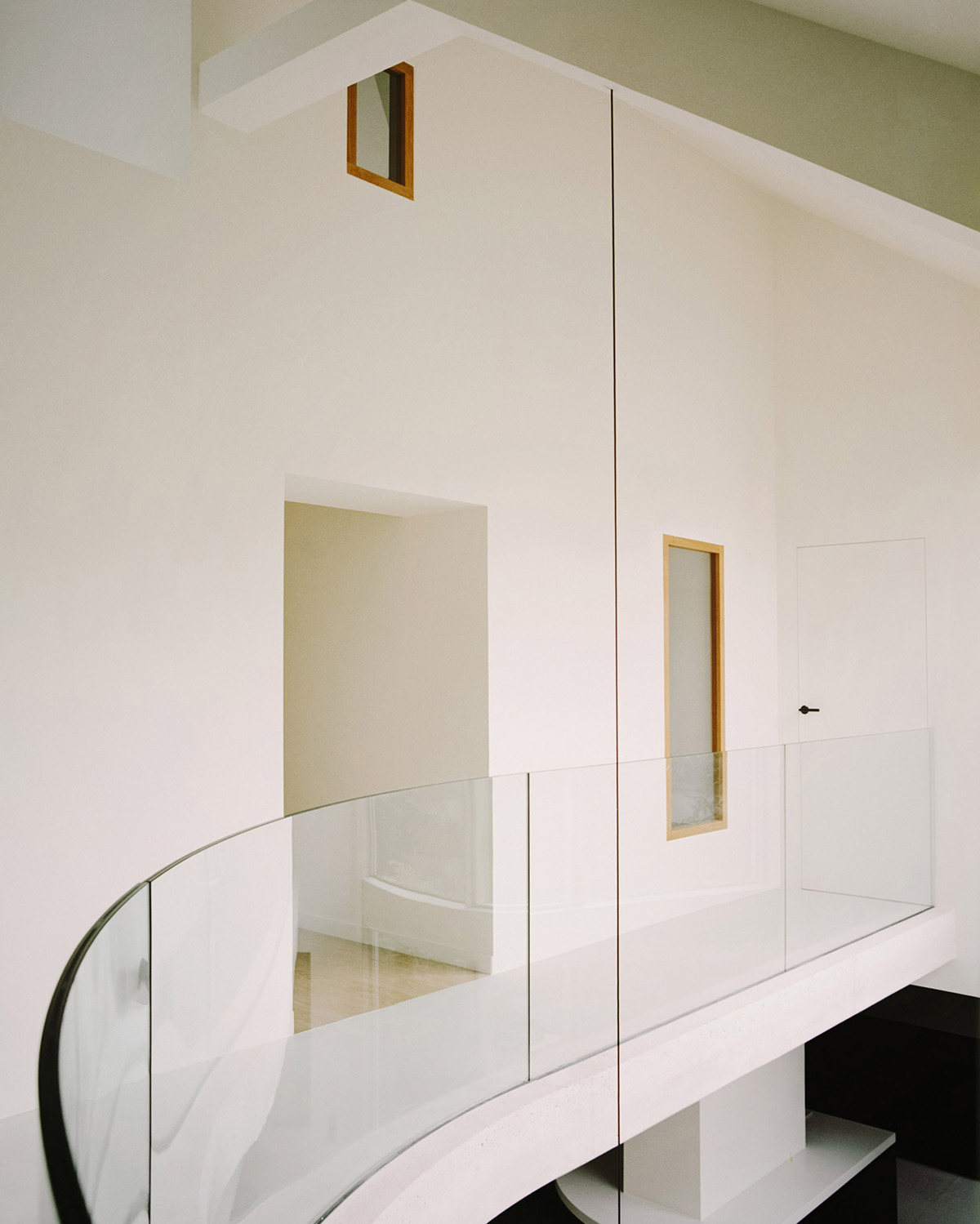 White concrete curved bridge gently complements interiors of The Island House in Paris