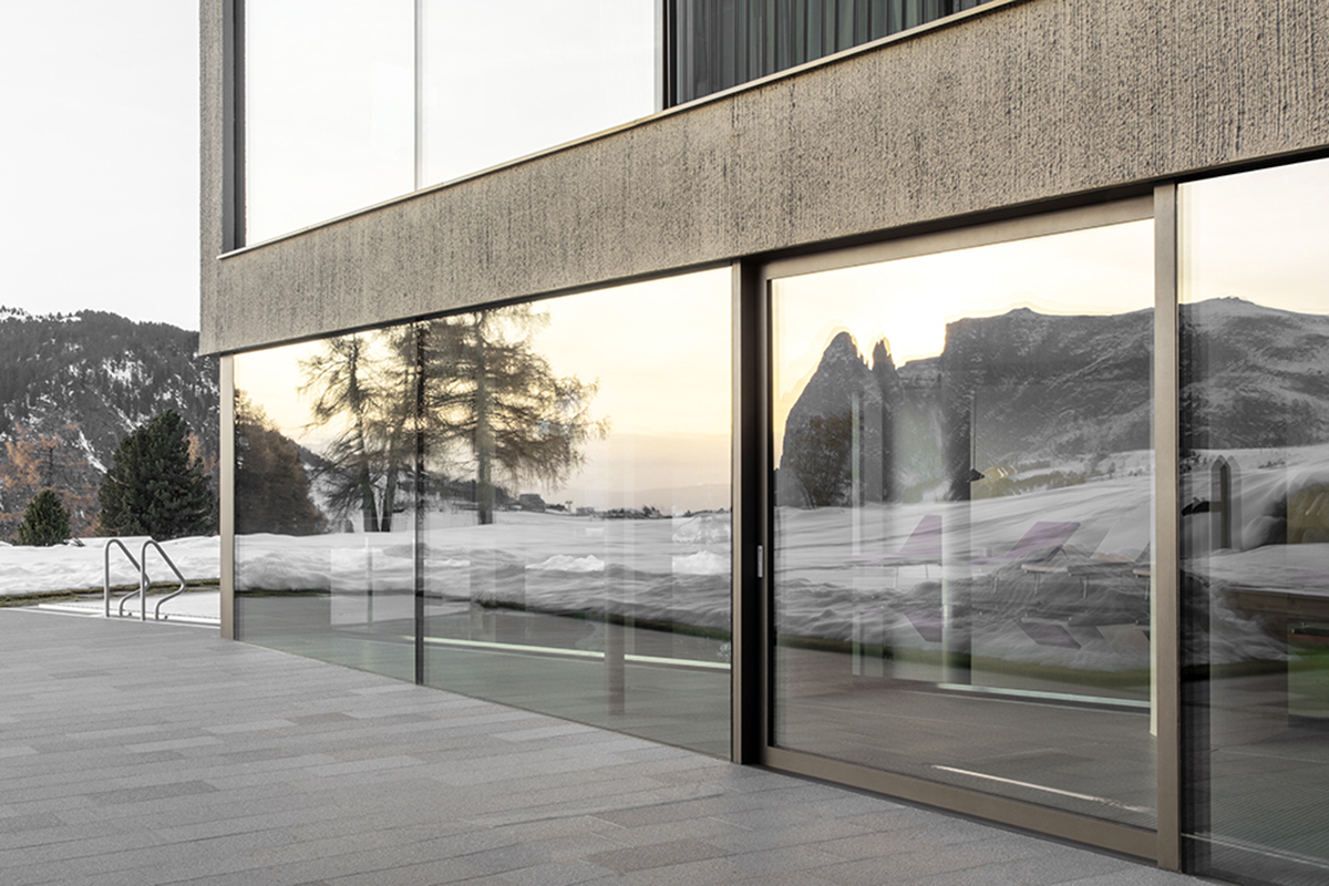 Icaro Hotel featuring wooden colonnade frames embraces alpine heritage landscape in Italy 